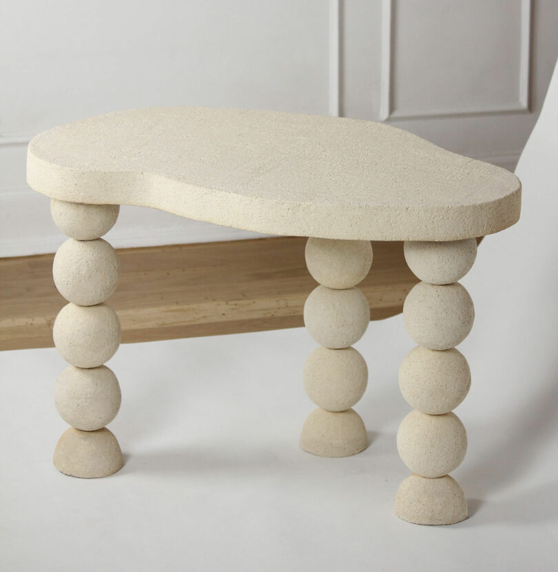 beige ceramic table with three stacked ball legs 