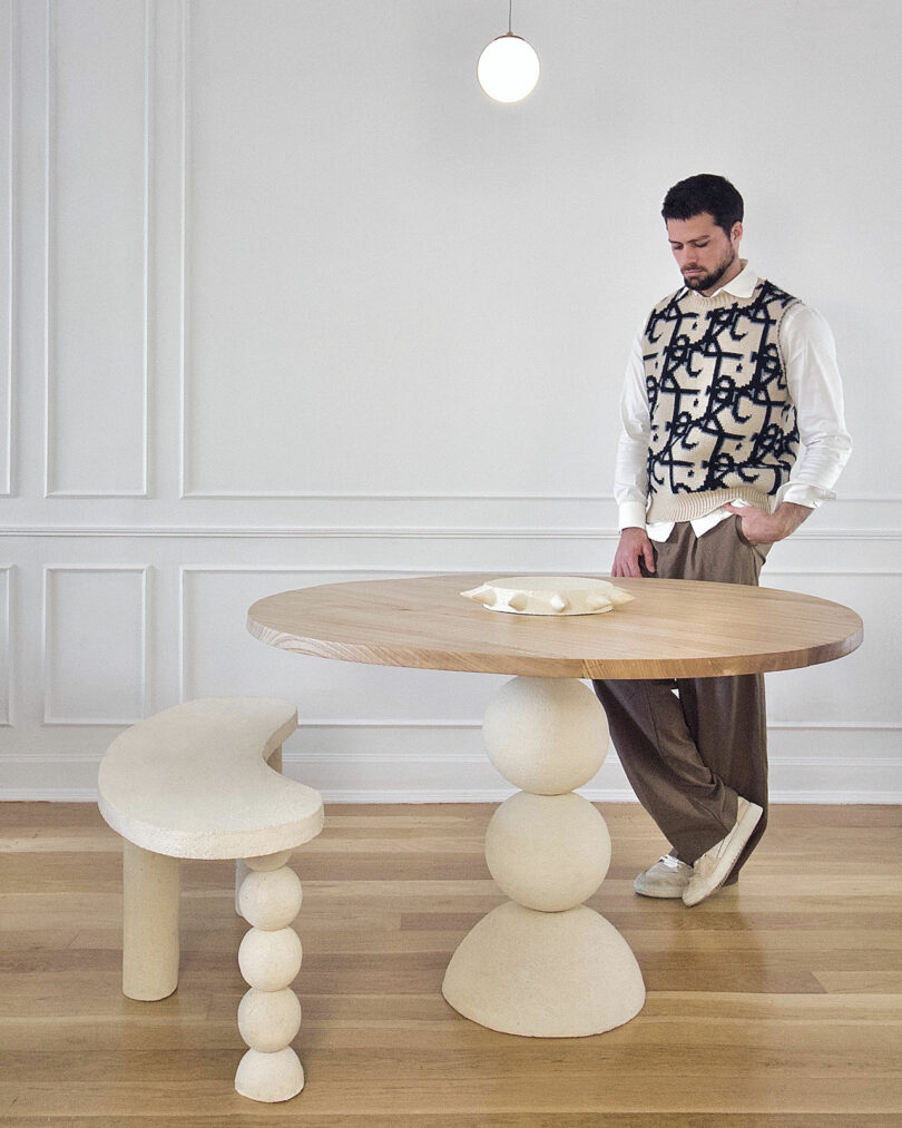 man standing next to two ceramic tables