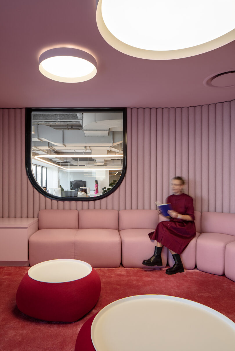 woman sitting in pink and red meeting room
