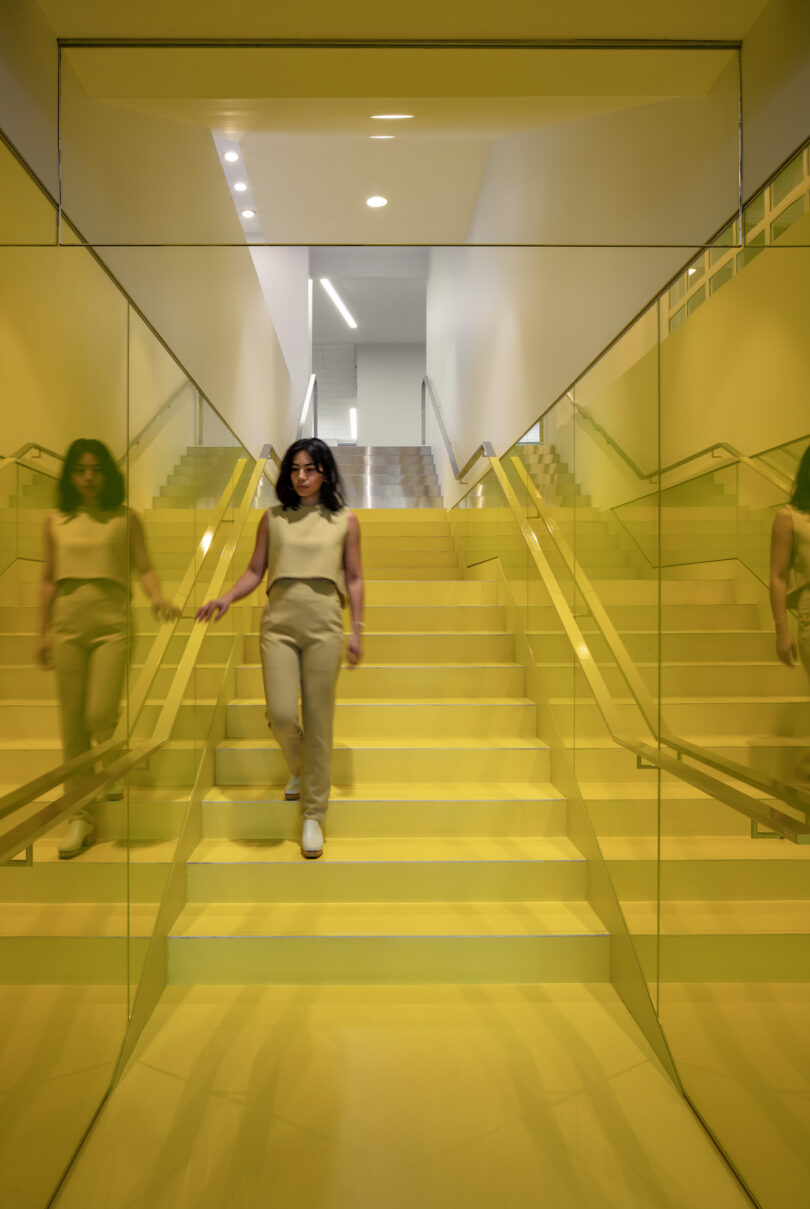 woman walking down yellow stairwell