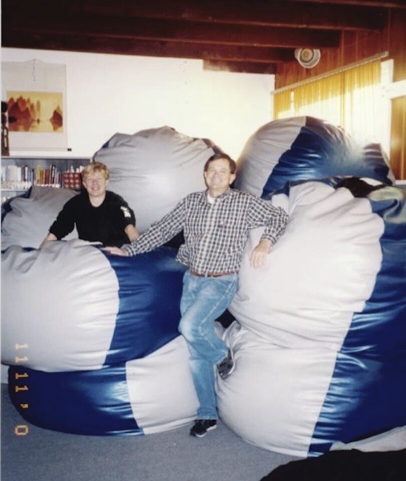 two men standing next to white and blue beanbags