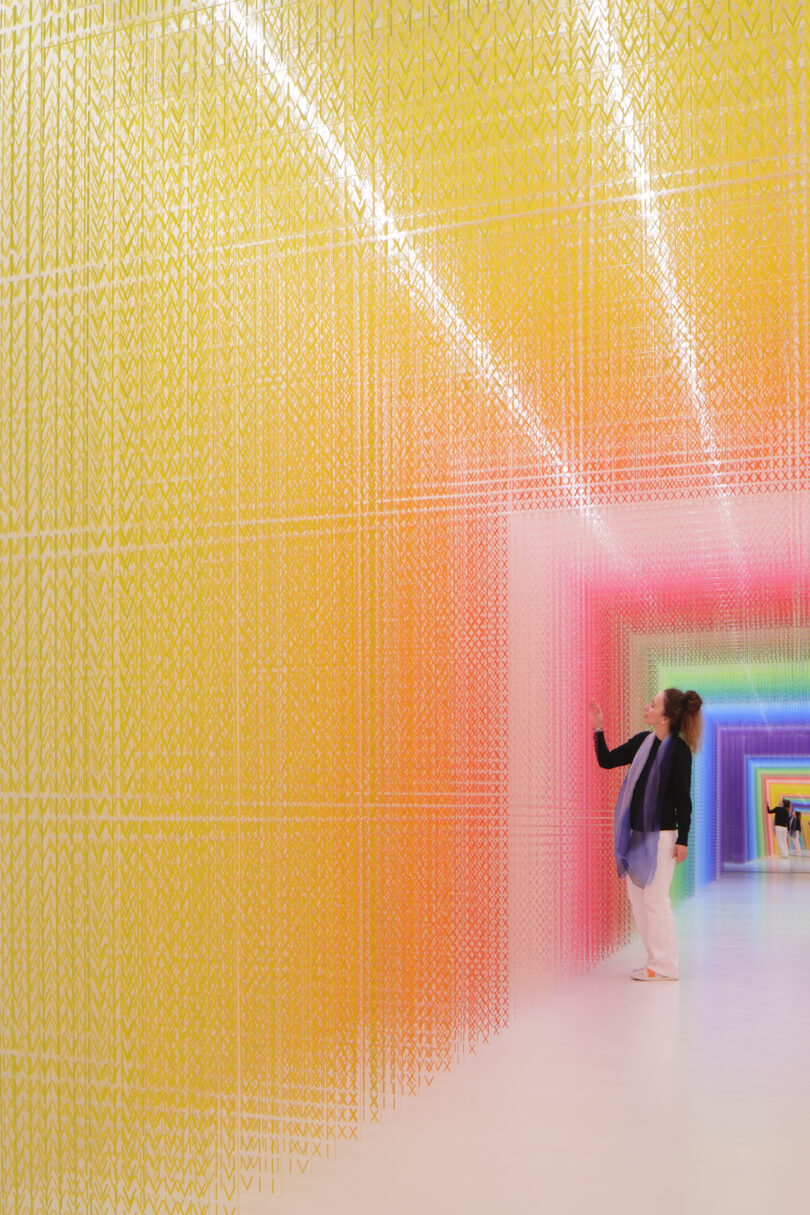 woman stepping done a colorful installation of acrylic transparent sheets