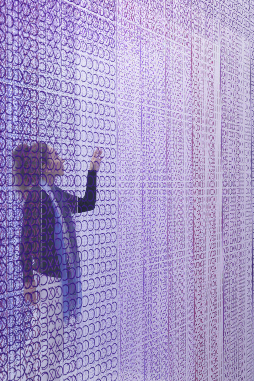 woman touching a colorful installation of acrylic transparent sheets
