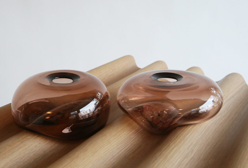 wood console surface with two glass vases on it