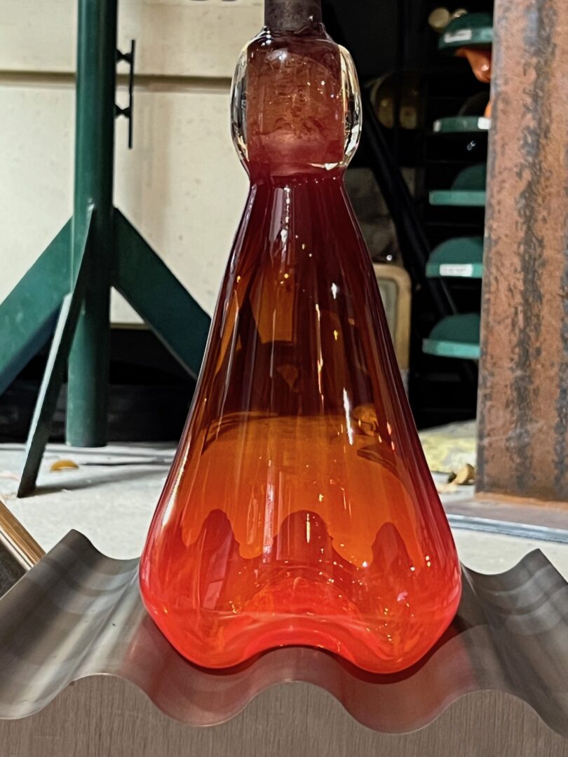 red glass vase on wavy metal