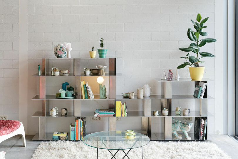 aluminum modular shelving system with books and objects on it