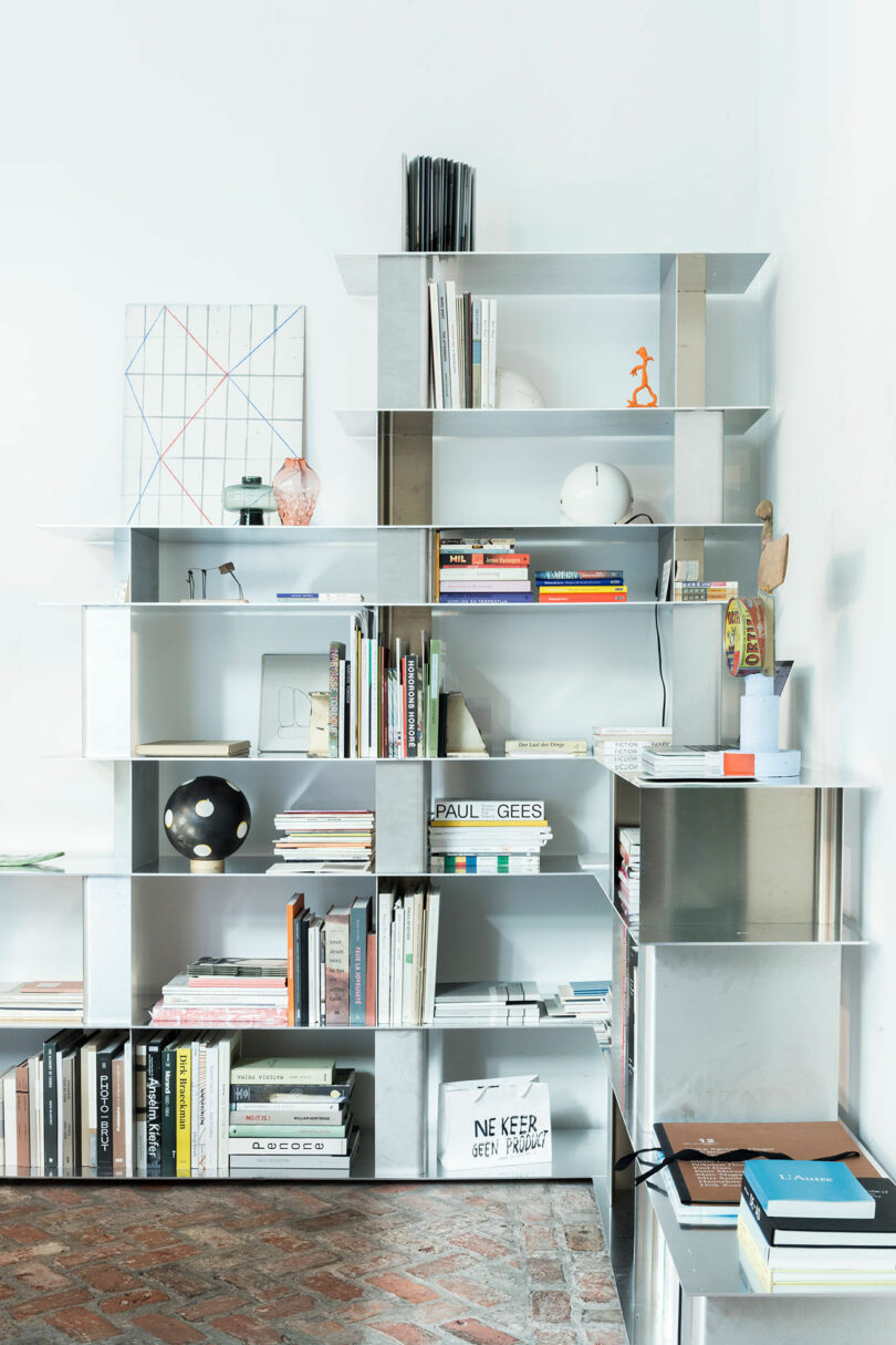 aluminum modular shelving system with books and objects on it