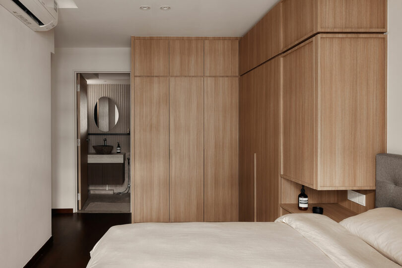 side view of modern bedroom with medium wood built-in cabinet storage