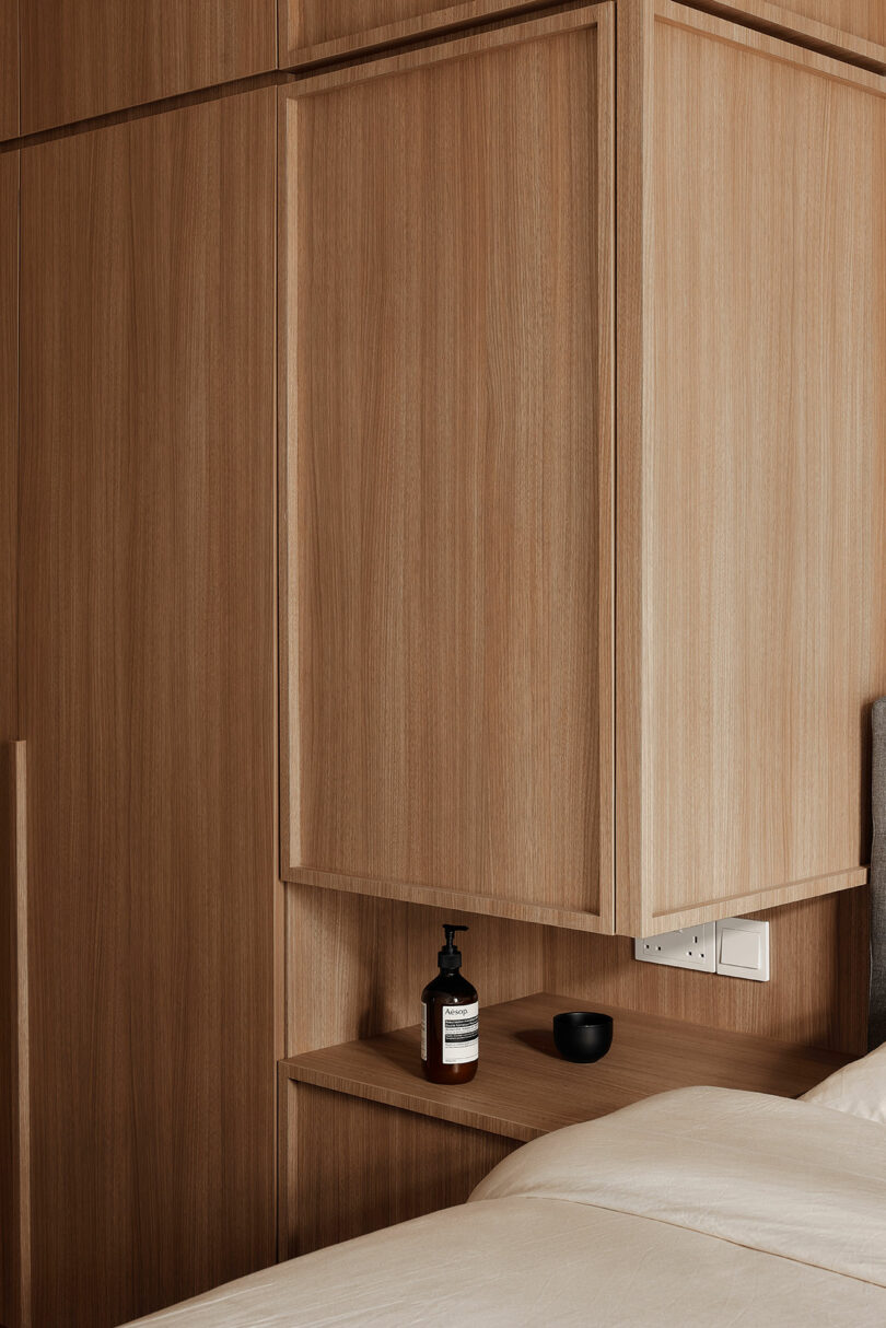 angled partial view of modern bedroom with built-in wood storage cabinets