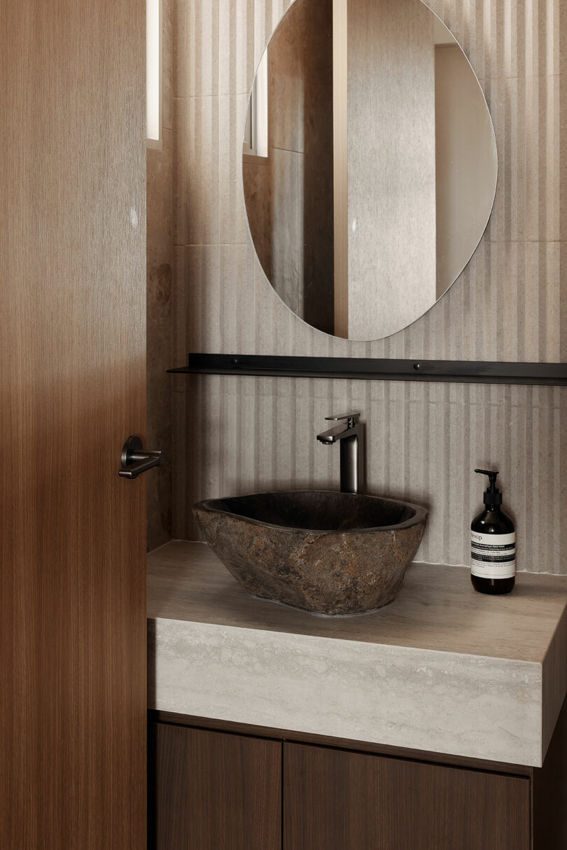 partial angled view of modern bathroom with vessel stone sink