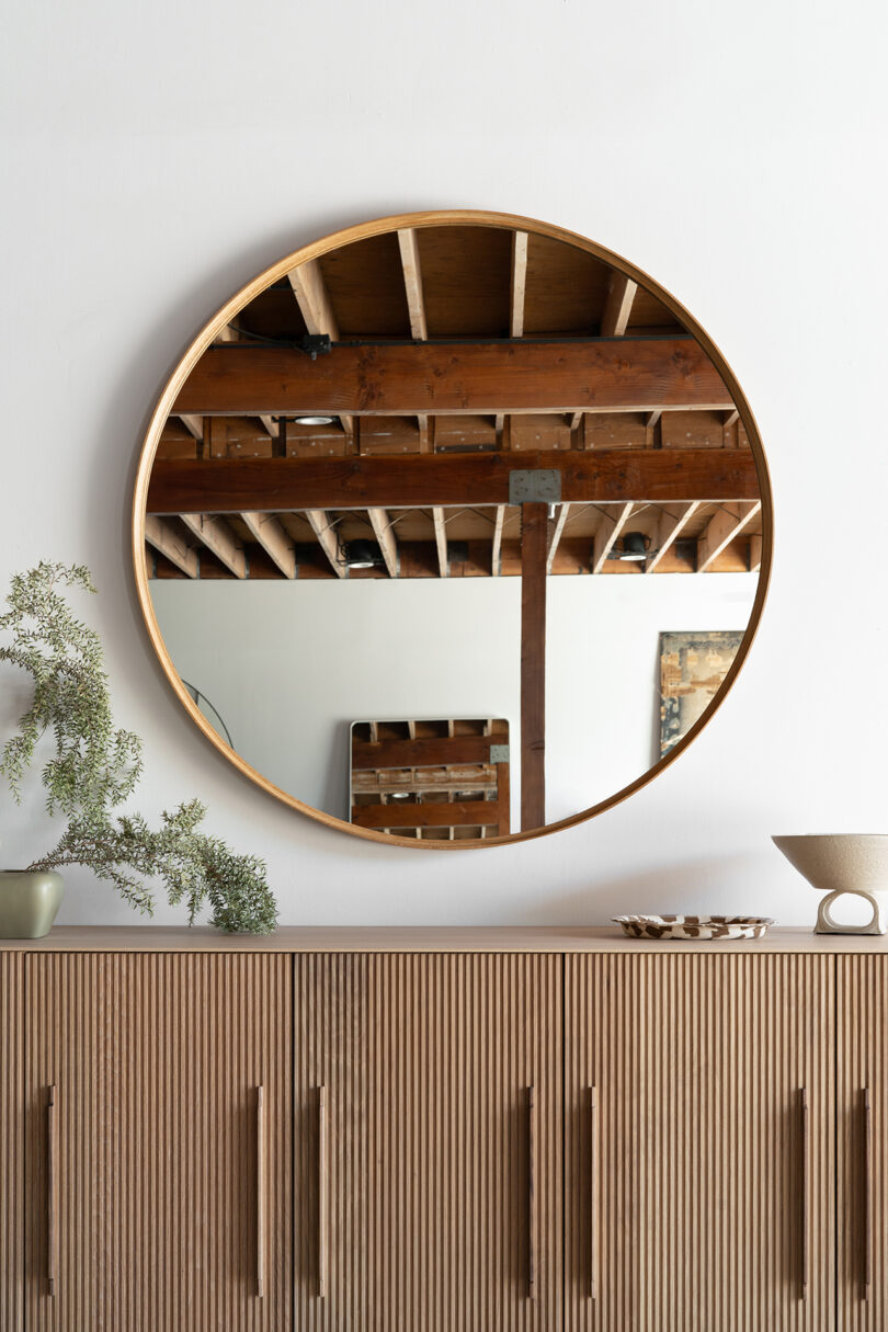 modern wood credenza and wood framed round wall mirror