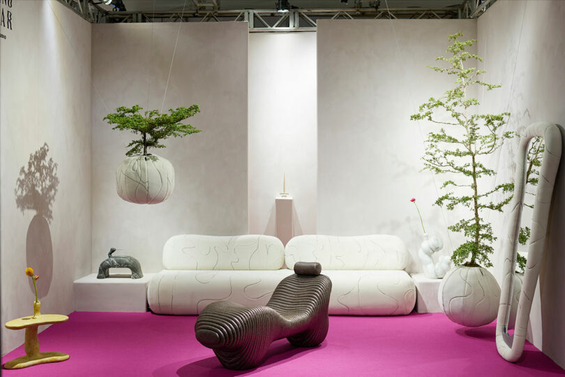 An exhibit with highly tactile home furnishings like seating, planters, a mirror, and tabletop items.