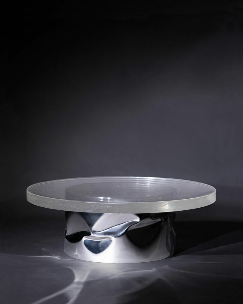 dark moody space with low coffee table made of round glass and crunched metal base