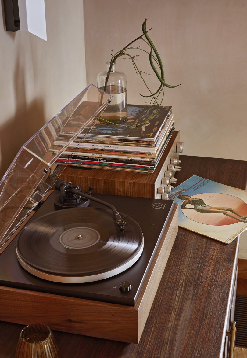 Toca-discos de estilo vintage com pilhas de discos nas proximidades