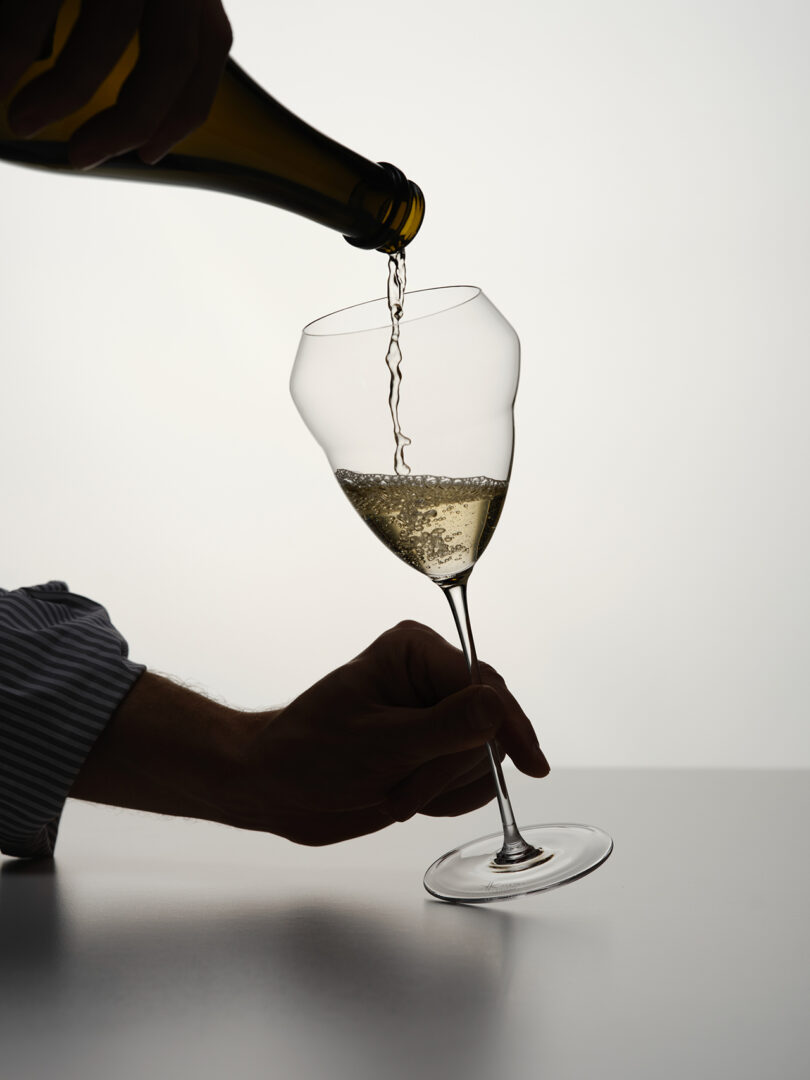 white wine being poured into a white wine glass