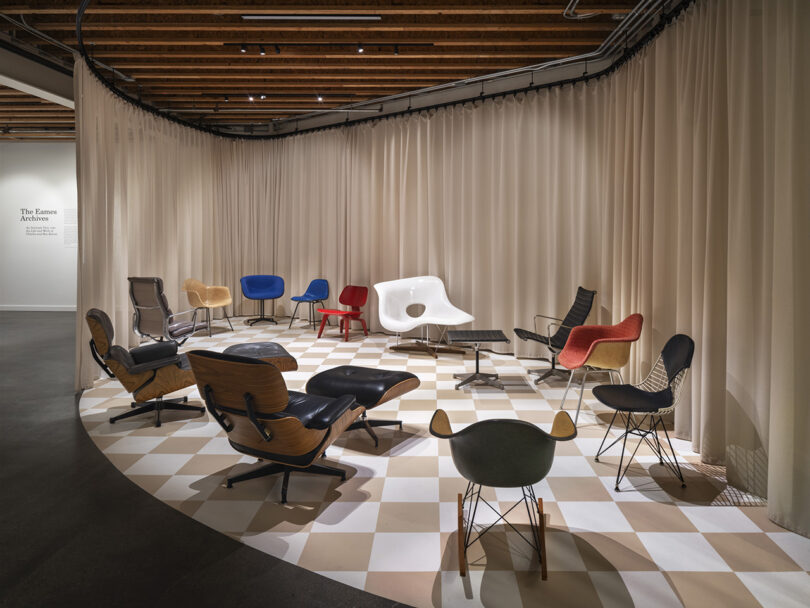 Checkerboard floor pattern platform display showcasing Eames designed chairs within the new Eames Archives in Richmond, California