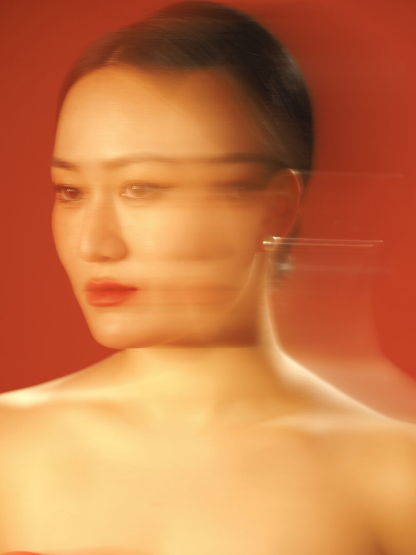 blurry photo of a woman with pulled back dark hair and red lips