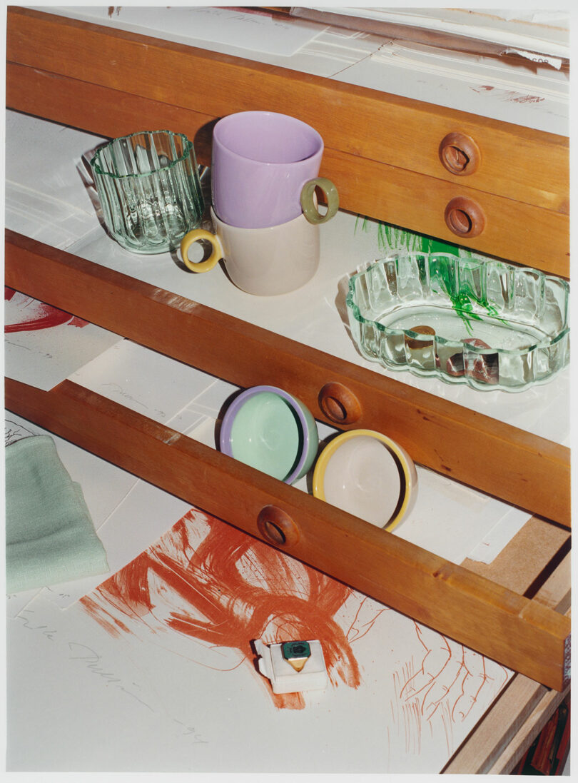 Glassware and ceramics strewn about a dresser.
