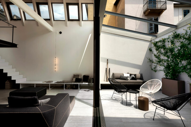 Toma separada de una sala de estar moderna de un apartamento moderno con vista exterior al patio interior.