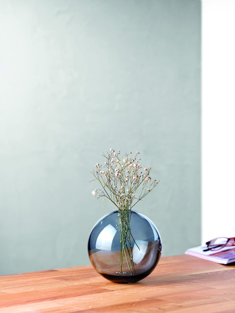 round blue glass vase with flowers