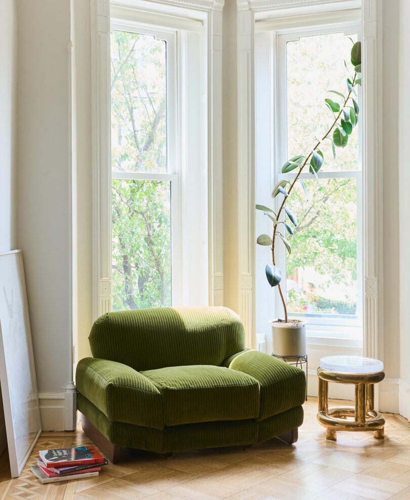 An oversized corduroy lounge chair in a living space in front of a window.