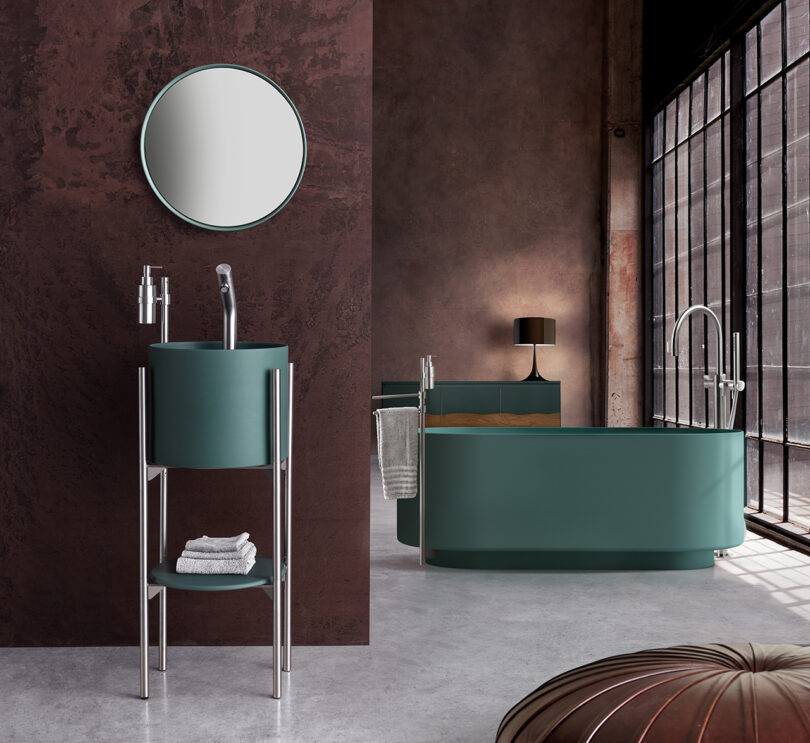 dark green cylindrical sink console and matching bath tub in a styled bath