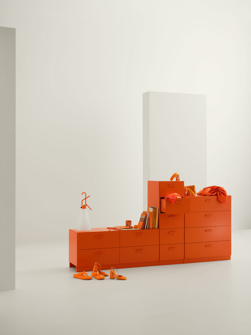 A white set staged with a variety of orange modular dressers.
