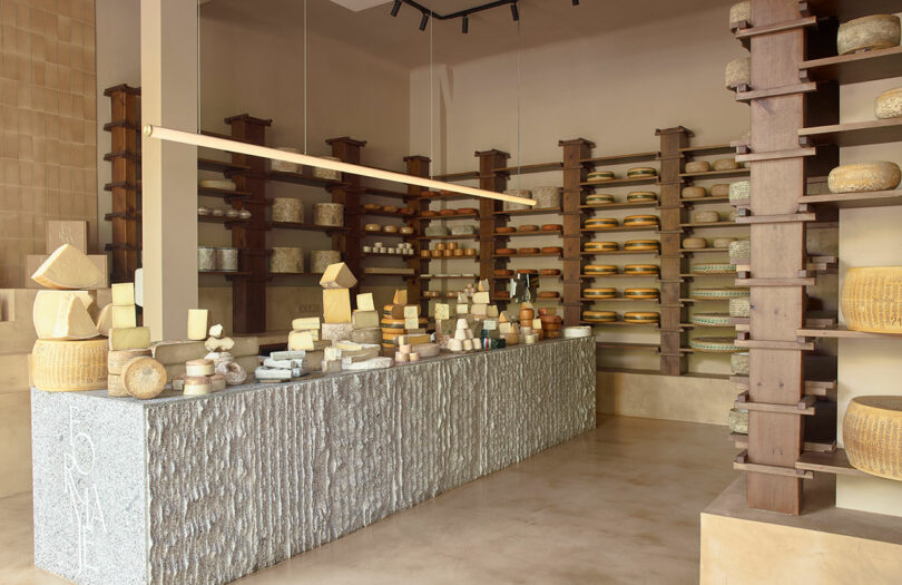 angled view of modern cheese shop with stone front counter holding various cheeses