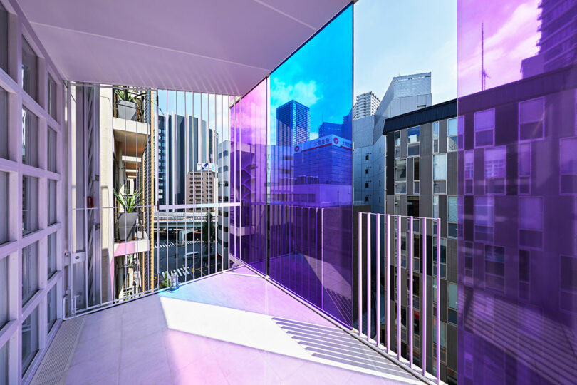 angled angled interior view of modern office space looking out to balcony with blue and purple exterior glass