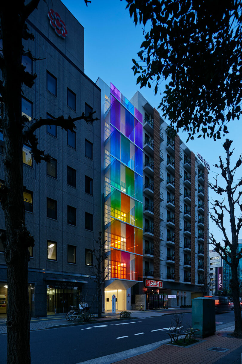 نمای بیرونی شبانگاهی زاویه دار ساختمان مدرن با نمای رنگین کمانی