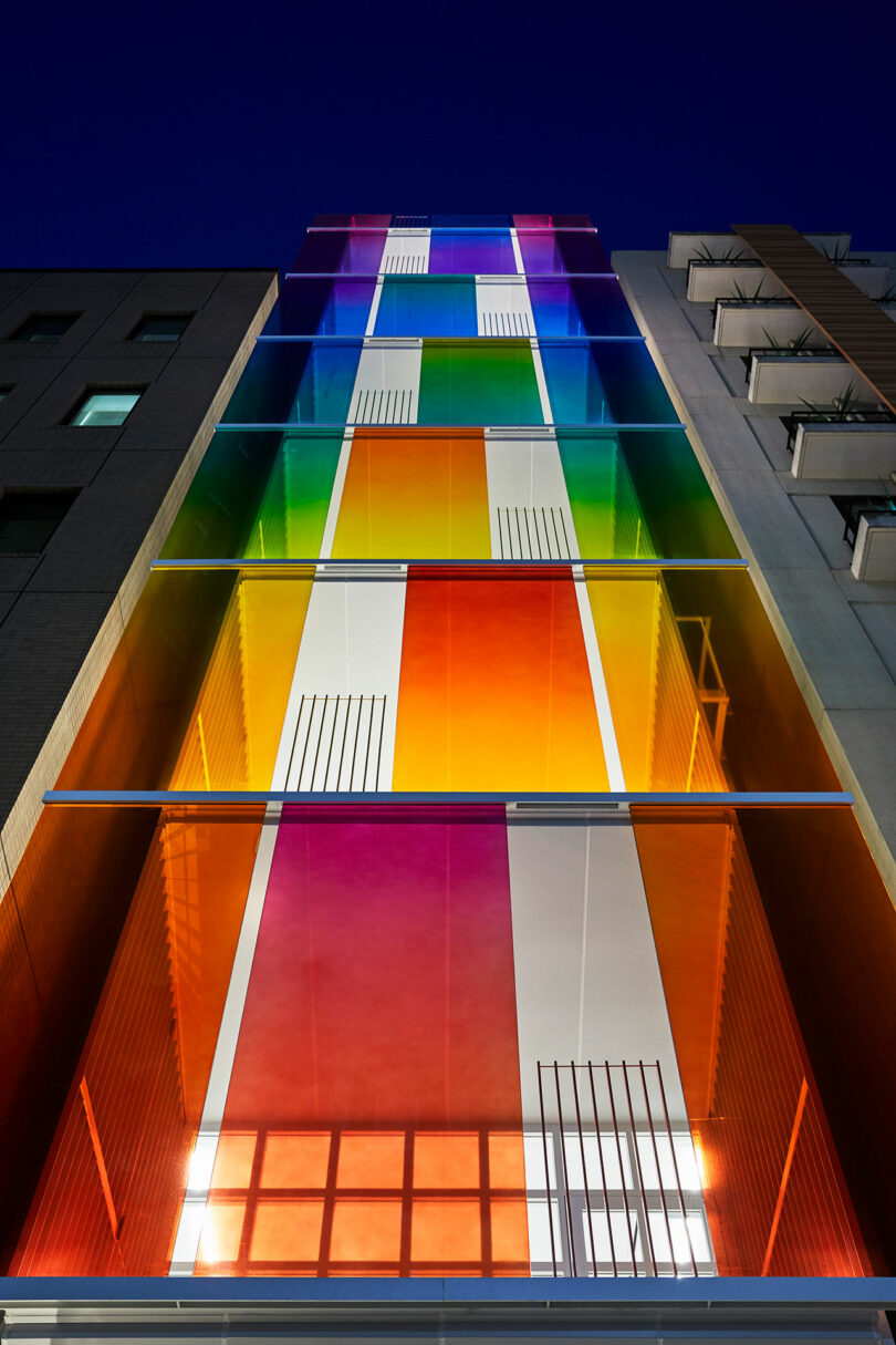 نمای بیرونی عصر رو به بالا از ساختمان مدرن با نمای رنگین کمانی