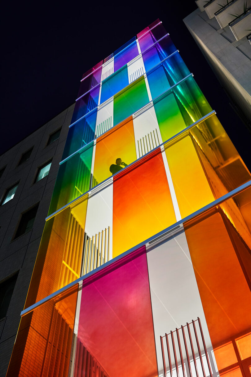 نمای بیرونی عصرگاهی به سمت بالا از ساختمان مدرن با نمای رنگین کمانی