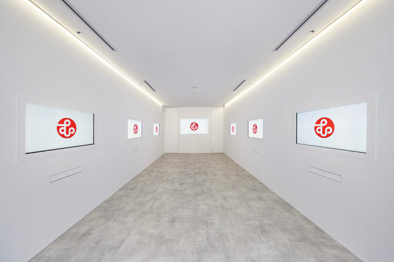 interior shot of white office building with white and red art on walls