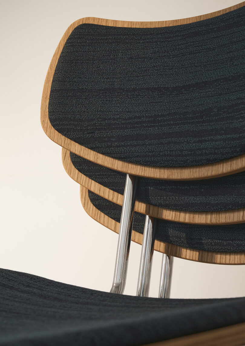 detail of stacked wood and chrome dining chairs with black upholstery