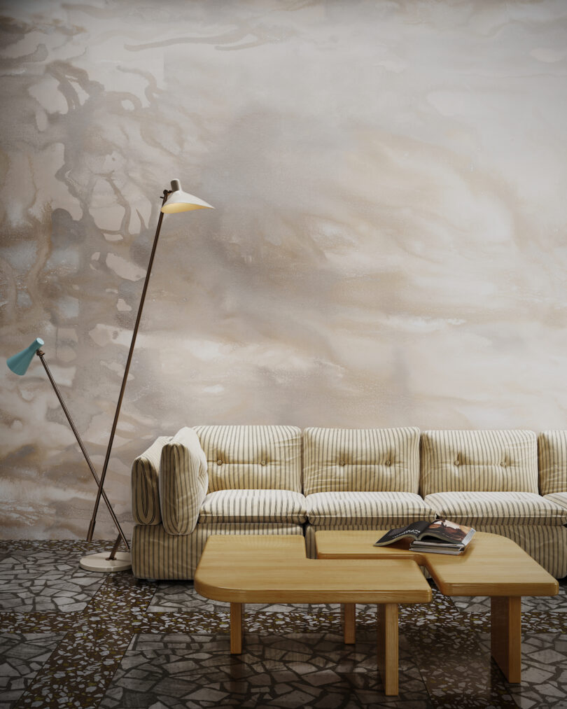 striped sofa with two long floor lamps in wallpapered room