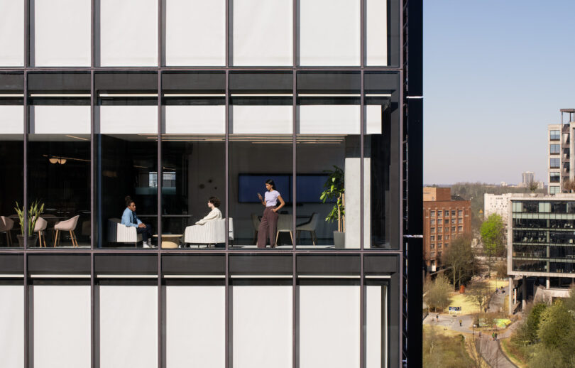 view of three employees working next to a window in a high rise office