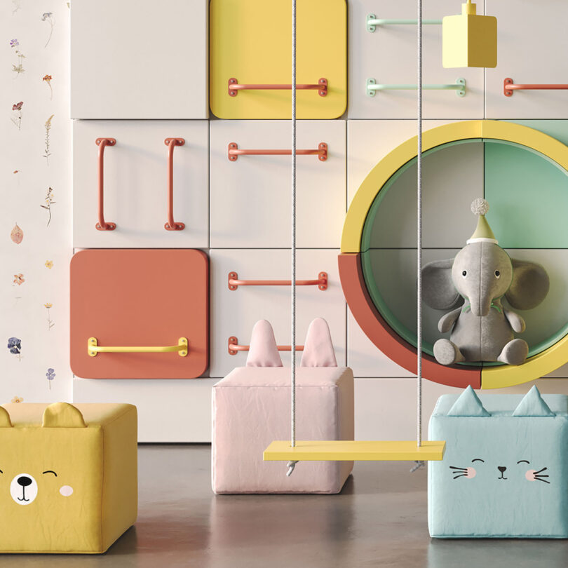 Colorfully decorated kid's room decorated with animal shaped cube seats, large stuffed animal elephant, hanging swing from the ceiling, and a multicolor arrangement of Randle Wall Climbing Handles spanning the walls.