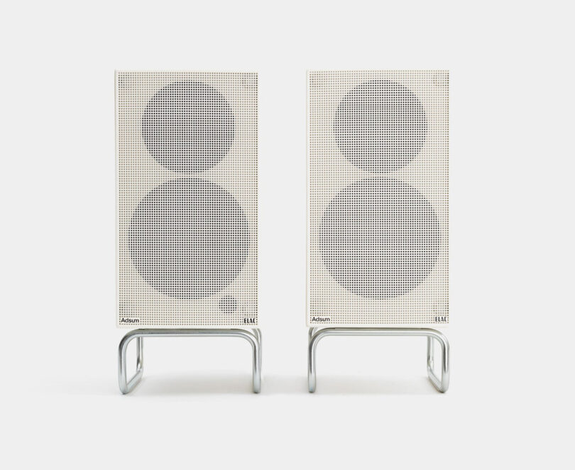 Two white modern minimalist with Adsum + ELAC Debut CONNEX DCB41 audio speakers with their grilles on set against a white background.