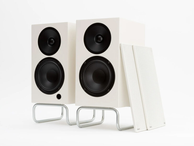 A set of modern Adsum + ELAC Debut CONNEX DCB41 audio speakers with each of their magnetic grilles taken off to expose their dual black drivers.