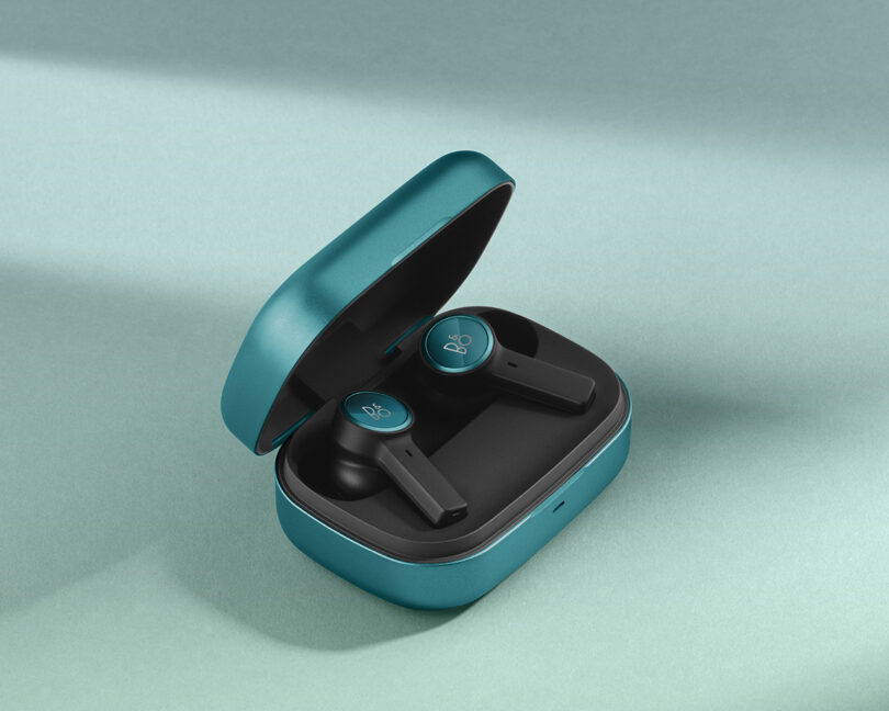 Northern Sky Turquoise Bang & Olufsen wireless earbuds in an open charging case 