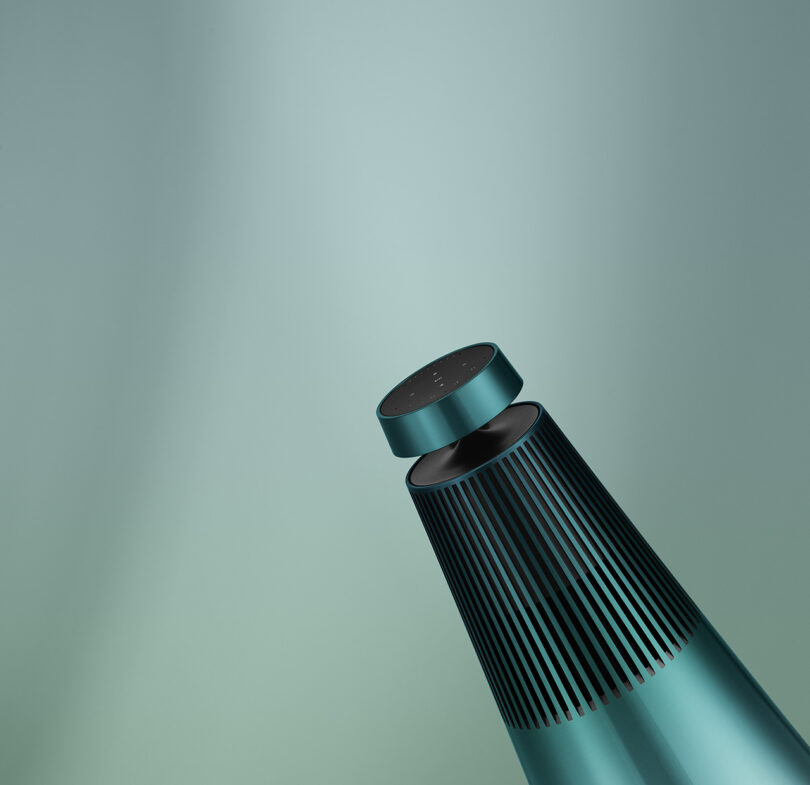 Beosound 2 wireless speaker hued in Northern Sky Turquoise set against a gradient background.