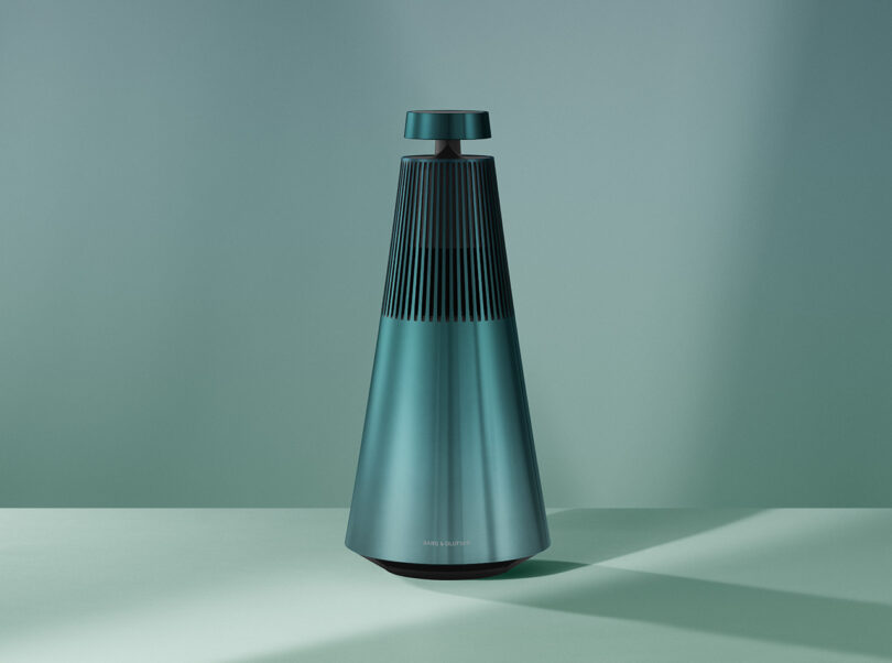 A sleek, modern designed wireless speaker with a ribbed texture standing against a monochromatic background.