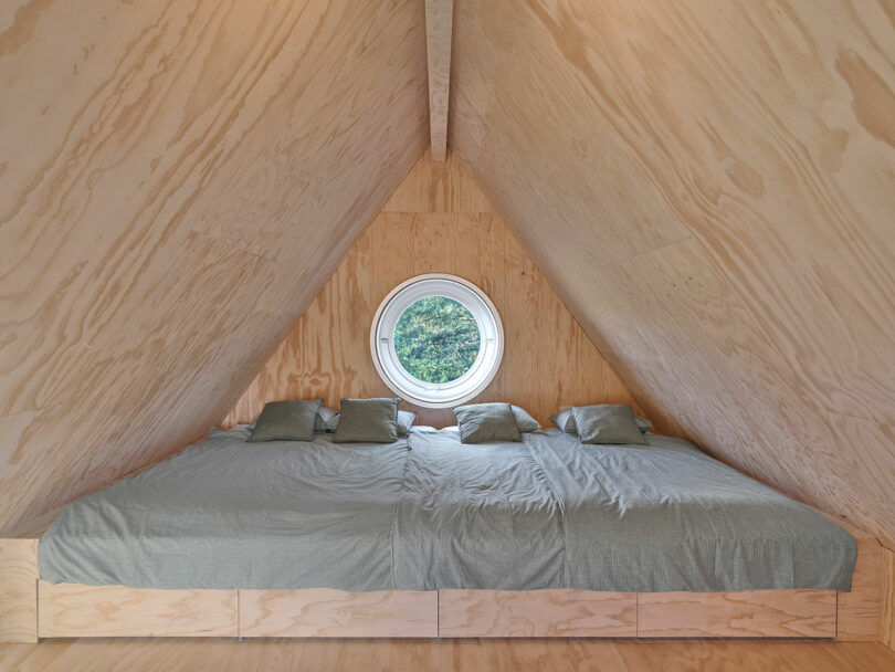 A bed in a triangular room of modern cabin.