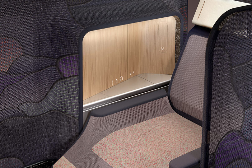 Premium cabin aircraft seat with privacy shell, woodgrain paneling, and integrated personal lighting.