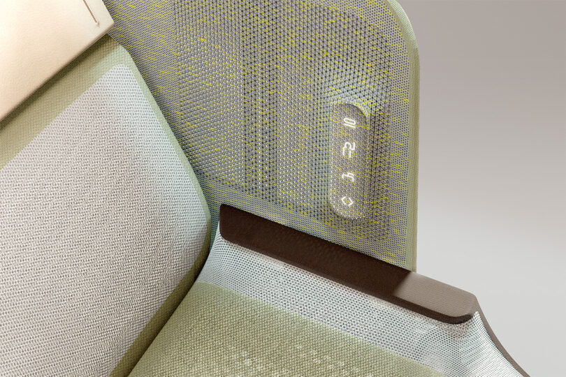 Close-up of a plane seat with 3D woven textile and touch panel controls illuminated through the fabric.