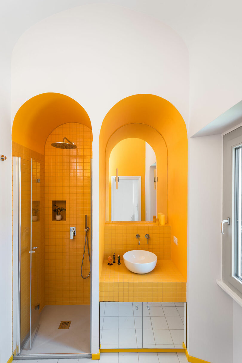 view of two small arched spaces one with a yellow shower and the other with a yellow sink