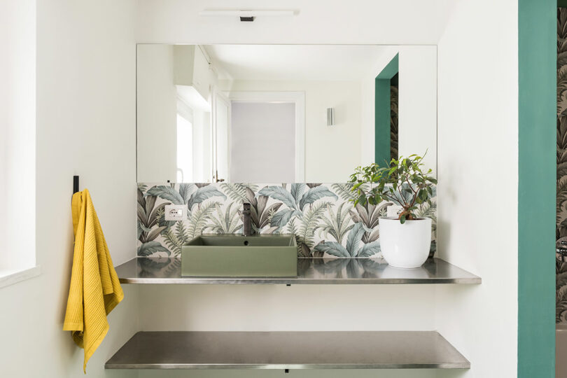 modern bathroom with moss green sink and tropical green wallpaper