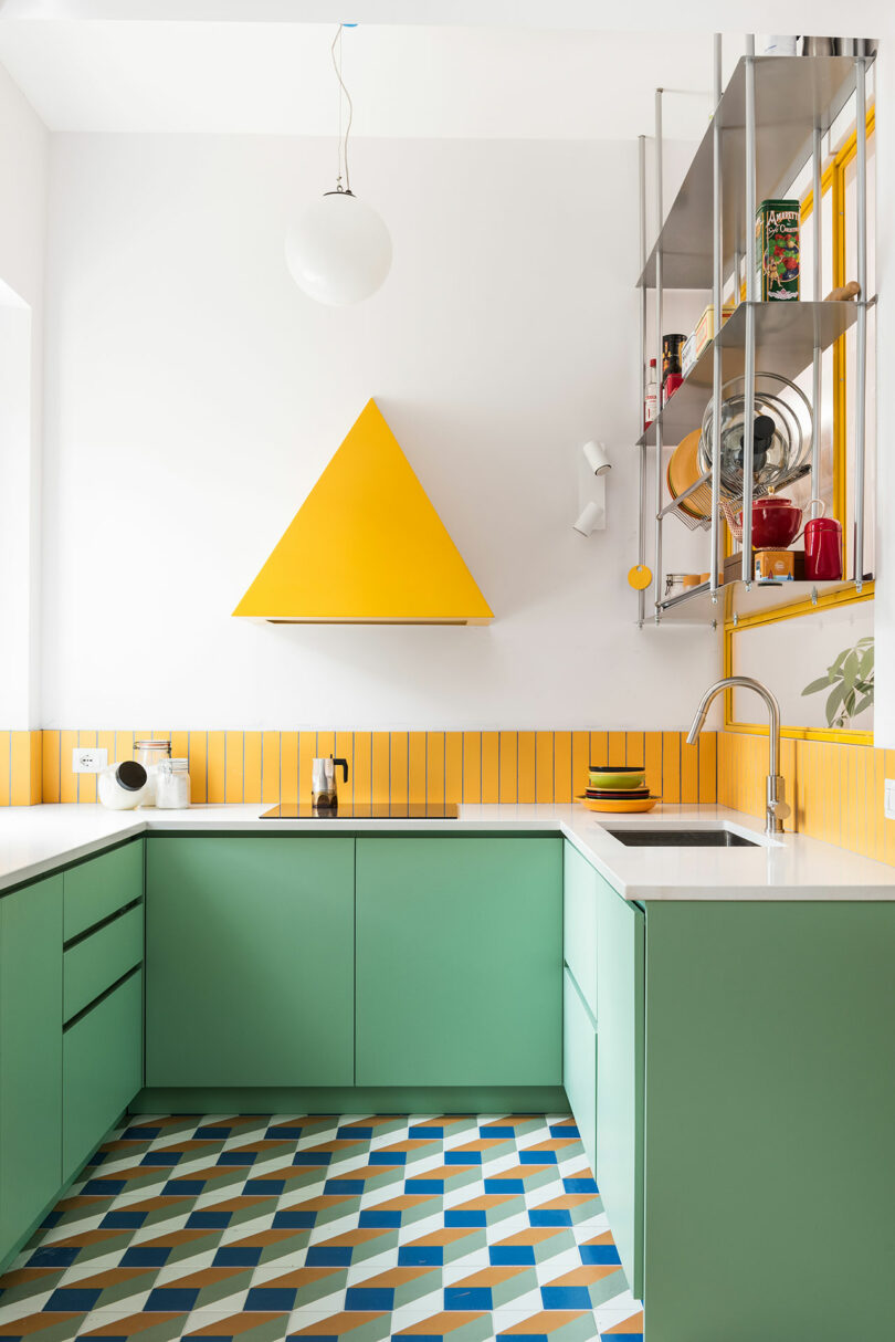 A yellow and blue kitchen with a triangle on the floor.