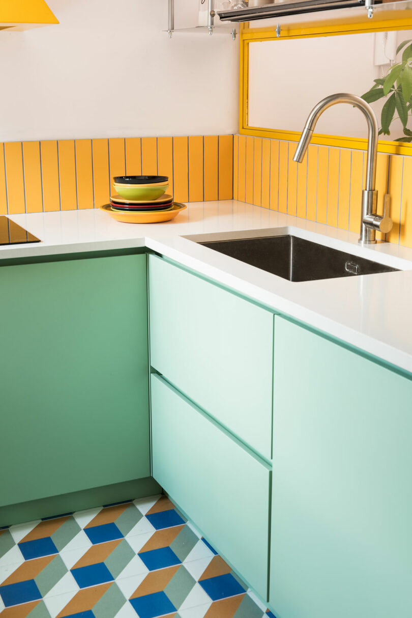 A kitchen with green, yellow and blue colors.