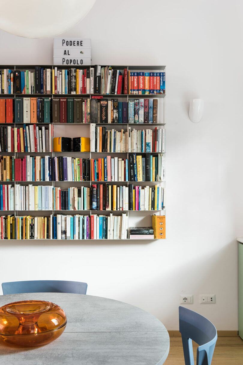 A room with a table and chairs and a bookshelf.